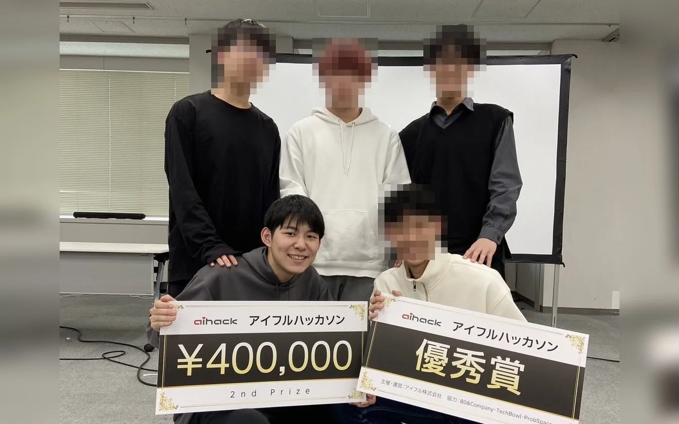 アイフルハッカソンで優秀賞のボードを持つチームの集合写真(本人以外の顔はモザイク処理)
