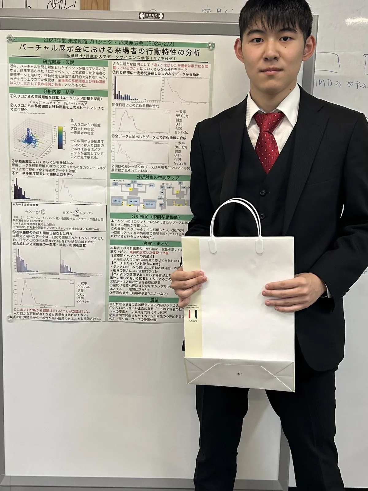 成果発表会で研究ポスターの横に立つ松田悠杜